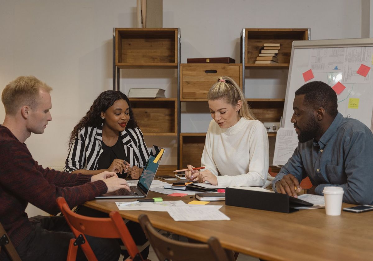 A revenue cycle team discussing account performance around a meeting table