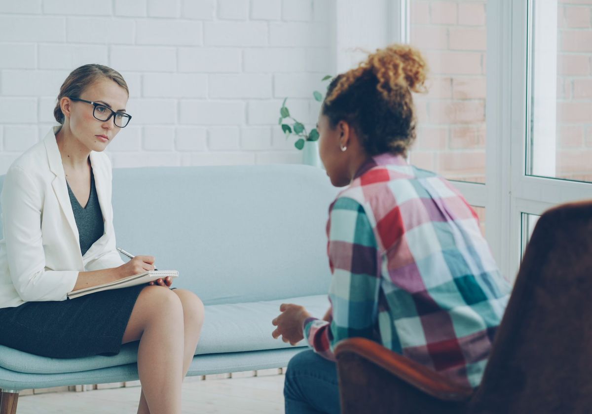 A therapist in a counseling session with a client in a bright office