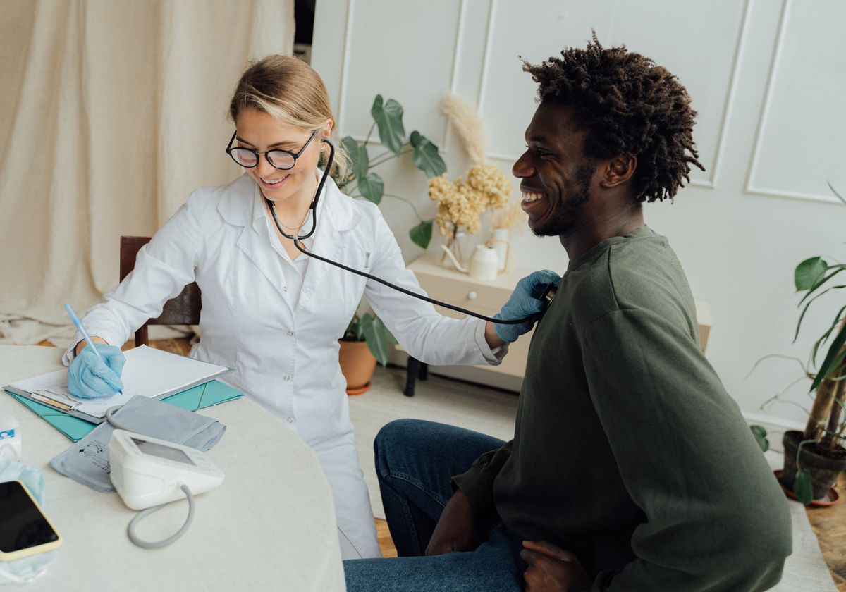 A physician listening to a patient’s heart with a stethoscope