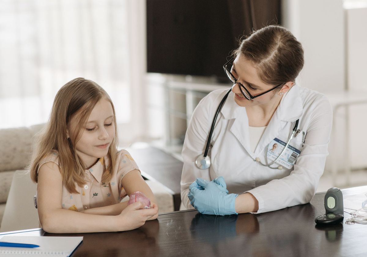 A pediatrician examining a young girl during a check-up
