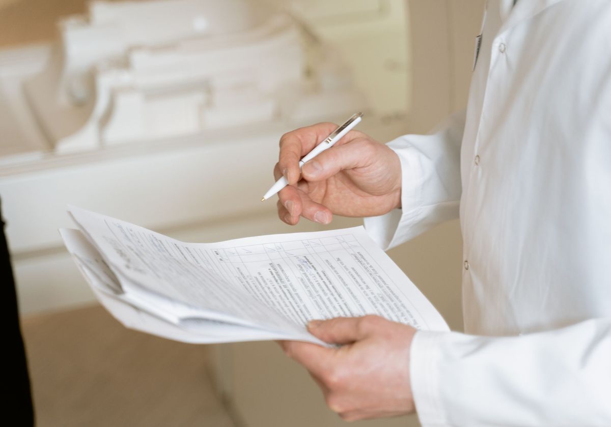 A physician reviewing and signing a credentialing document